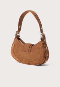 Brown suede handbag with a curved shape, short strap, and silver hardware accents. Features a zip closure and stitch detailing.