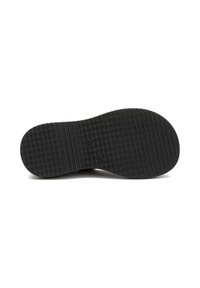 Suola di scarpa in gomma nera con superficie testurizzata, caratterizzata da un motivo ondulato e un tacco arrotondato. Design piatto e ampio per maggiore stabilità.