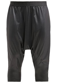 Schwarze, locker sitzende Reebok-Cropped-Hose mit elastischem Bund, Reebok-Logo und glänzendem, glattem Stoff.