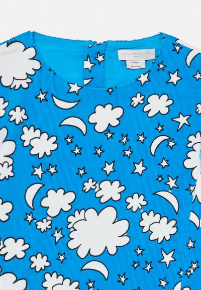 Modrá látka s bielym vzorom oblakov, hviezd a polmesiacov na výstrihu detského oblečenia s etikietou.