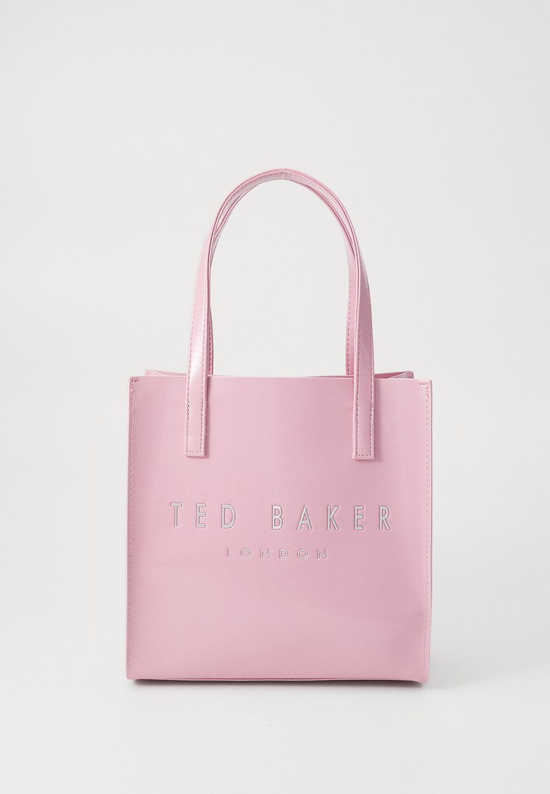 Vaaleanpunainen keinonahkainen olkalaukku, jossa on sileä pinta. Varustettu hopealla kohokuvioidulla "TED BAKER LONDON" -logolla ja tyylikkäillä, lyhyillä kahvoilla.