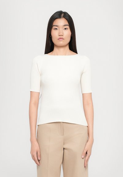 White ribbed top with short sleeves, round neckline, and a fitted silhouette, paired with beige wide-leg trousers.