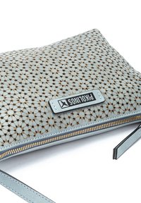 Funda de piel de color azul claro con un diseño floral perforado, detalles en dorado, cierre de cremallera y etiqueta de marca.