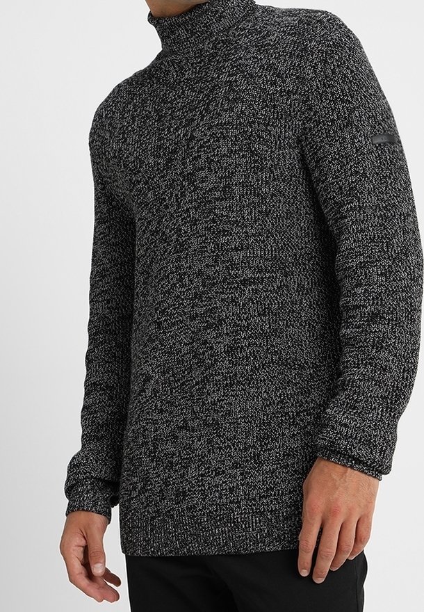 Schwarzer und grauer gemusterter Rollkragenpullover mit langen Ärmeln und strukturiertem Stoff; verfügt über ein Logo-Patch am linken Arm.