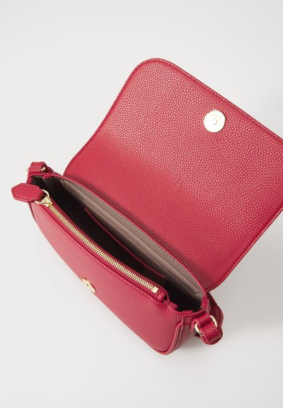 Geantă crossbody din piele roșie cu exterior texturat, accesorii din alamă aurie, compartiment cu fermoar și clapetă cu închidere magnetică.
