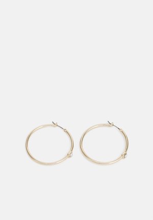 Gullfargede hoops med en glatt, rund design, som har en liten klar edelsten som pynt ved låsen.