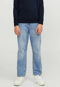 Jeans de mezclilla azul claro con corte recto, combinados con un sudadera azul marino y zapatillas blancas, con costuras estándar y sin adornos visibles.