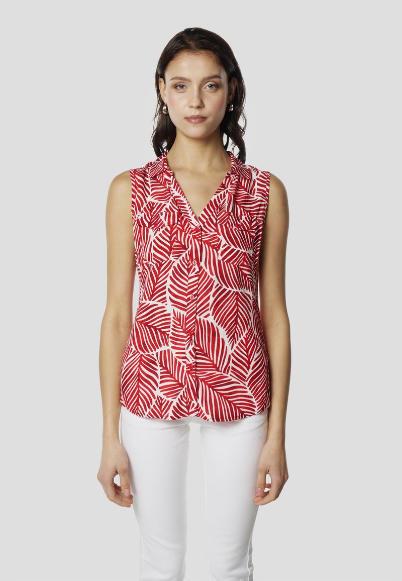 Blusa sin mangas roja y blanca con un patrón de hojas, cuello con solapa y cierre frontal con botones. La tela parece ligera y suave.