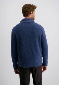 Marineblaues Strickpullover mit einer strukturierten, flauschigen Oberfläche, geripptem Kragen und Saum. Das Design bietet eine lockere Passform und lange Ärmel.