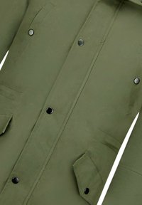 Olijfgroene jas met drukknopen, twee voorzakken en een duurzame stoftextuur. Rechte snit met een strak, minimalistisch uiterlijk.