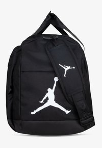 Juodos medžiagos kuprinė su baltu Jumpman logotipu. Turi tvirtą užtrauktuką, reguliuojamus dirželius ir mažą nuimamą etiketę. Tekstūruota paviršius.