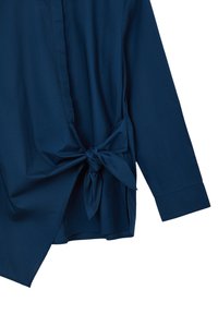 Marineblaues, langärmliges Shirt mit einem geknoteten Akzent in der Taille, hergestellt aus glattem Stoff mit einem halbstrukturierten Design.