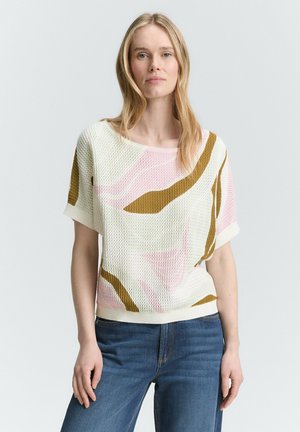 Pull en maille à manches courtes de couleur blanche avec des motifs abstraits multicolores en rose et marron. Surface texturée avec une coupe décontractée.