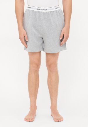 Graue Baumwoll-Boxer mit elastischem Bund, der das Logo "Calvin Klein" trägt. Einfaches Design, gerader Schnitt und weiche Textur.