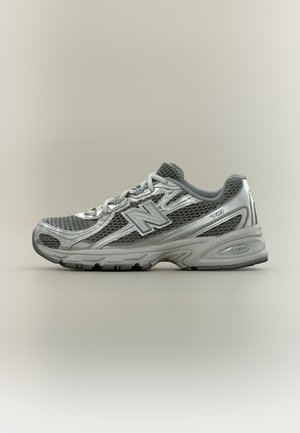 Grauer und silberner New Balance 740 Laufschuh mit Mesh-Obermaterial, Schnürsenkeln und sichtbarer ABZORB-Dämpfung an der Seite.