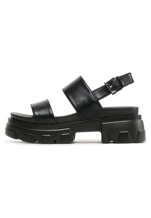 Czarne platformowe sandały ze skóry z dwoma szerokimi paskami i regulowaną klamrą. Teksturowana gumowa podeszwa o masywnym designie z elementami zapewniającymi przyczepność.