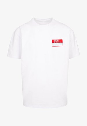 Biała bawełniana koszulka z okrągłym dekoltem, krótkimi rękawami i czerwoną metką "Hej! Mam na imię" na lewej piersi. Widoczne realistyczne odcienie skóry i tatuaże.