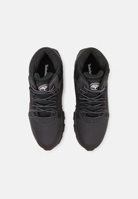 Schwarze Sportschuhe mit strukturierten Mesh-Oberteilen, verstärkten Zehenkappen und reflektierenden Schnürsenkeln. Mit Logo auf der Zunge und gepolsterten Sohlen.