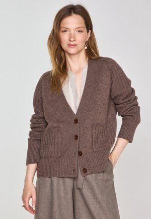 Cardigan in lana marrone con maniche a costine e due tasche frontali, caratterizzato da bottoni marrone scuro e un profondo scollo a V.