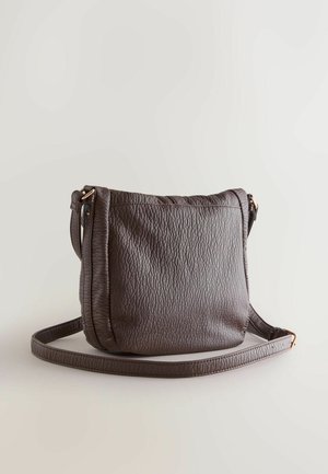 Geantă crossbody maro din piele texturată, cu o singură curea reglabilă și cusături subtile, având un sistem de închidere cu fermoar în partea de sus.