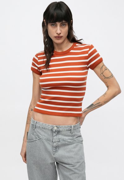 Ριγέ cropped τοπ σε καμένα πορτοκαλί και λευκό, ραβδωτό ύφασμα, κοντά μανίκια, στρογγυλή λαιμόκοψη, συνδυασμένο με ψηλόμεσα γκρι τζιν.