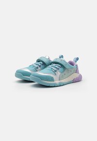 Zapatillas infantiles en tonos verde azulado y plateado con un estampado floral, cierre de velcro y detalles en púrpura; suela texturizada y cuello acolchado para mayor comodidad.