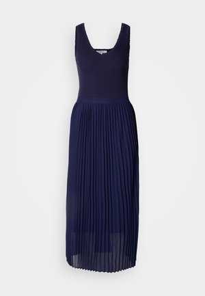 Tengerészkék ruha bordázott testrésszel, V-kivágással és redőzött, lágy szoknyával. Az anyag puha és könnyű textúrájú.