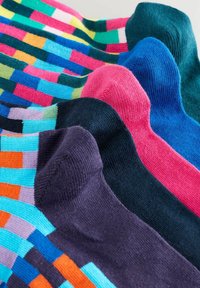 Bunte Socken mit einer Mischung aus einfarbigen und gestreiften Mustern. Strukturierter Stoff in lebendigen Farbtönen: Blau, Pink, Lila und Grün.