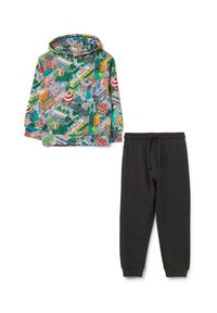 Sudadera con capucha con estampado colorido de un paisaje urbano, combinada con pantalones de chándal negros con cintura elástica y tobillos ajustados.