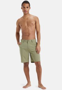 Szorty w kolorze khaki wykonane z mieszanki bawełny, wyposażone w zapięcie na guzik, szlufki na pasek oraz boczne kieszenie, zaprojektowane do noszenia na co dzień.