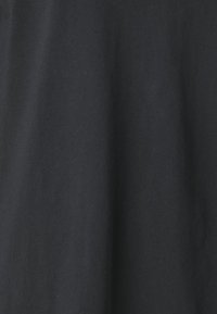 Tissu noir uni avec des plis doux et une surface lisse, légèrement texturée.