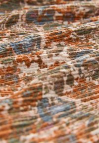Textured fabric in earthy tones of orange, brown, and green, featuring a abstract pattern with a soft, slightly ribbed surface.