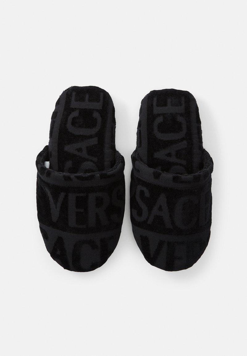 Sorte plydsandaler med et hævet logomønster. Designet er åbent foran med en rund form og blød tekstur for komfort.