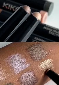 Twee oogschaduwstiften met een glanzende, zwarte behuizing. Staalmonster op de huid toont vier glinsterende tinten: roze, zilver, brons en goud.