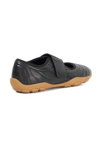 Black leather shoe with quilted design, Velcro strap, and a tan rubber sole. Features rounded toe and cut-outs for ventilation.