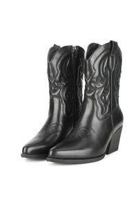 Botas de vaquero de cuero negro con puntera puntiaguda, cremallera lateral, patrón floral en relieve y tacones apilados. Textura suave con costuras decorativas.