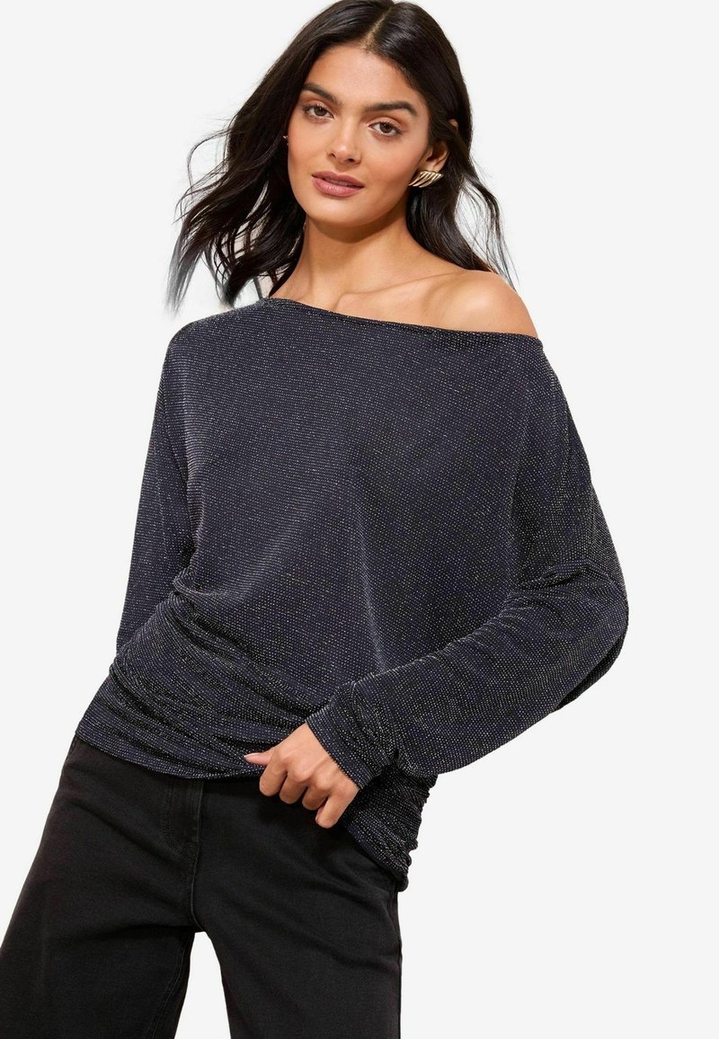 Top nero a spalle scoperte con maniche lunghe realizzato in un tessuto texturizzato e luccicante. Presenta una vestibilità comoda e dettagli arricciati in vita.
