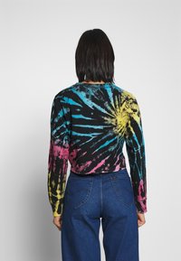 Long-sleeve tie-dye shirt featuring a black base with vibrant blue, yellow, and pink spiral patterns. Made of soft cotton fabric.