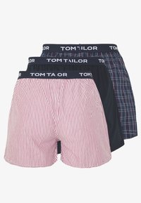 Three pairs of Tom Tailor boxers: red and white striped, solid navy, and navy plaid. Each features a navy waistband with brand logo.