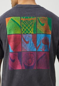 Black cotton t-shirt featuring a colorful graphic on the back, divided into nine sections with basketball-related imagery and textures.