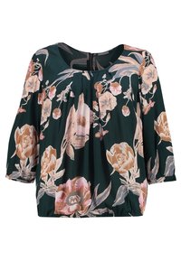 Blouse vert foncé avec grand imprimé floral rose et beige, encolure ronde, manches trois-quarts, ourlet froncé et plis à l'encolure.