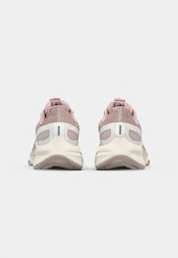Pink athletic shoes with mesh upper, padded collar, thick white sole, rubber tread, and subtle reflective accents. Rear view.