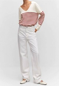 Valkoiset leveälahkeiset farkut, jotka on yhdistetty kerma- ja punaraitapaitaan, jossa on V-pääntie. Pehmeä kangas ja rento istuvuus.