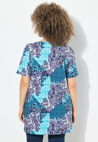 Kortærmet tunika med et patchwork-design, der har blå, turkise og lilla mønstre, lavet af blødt stof og med en afslappet pasform.