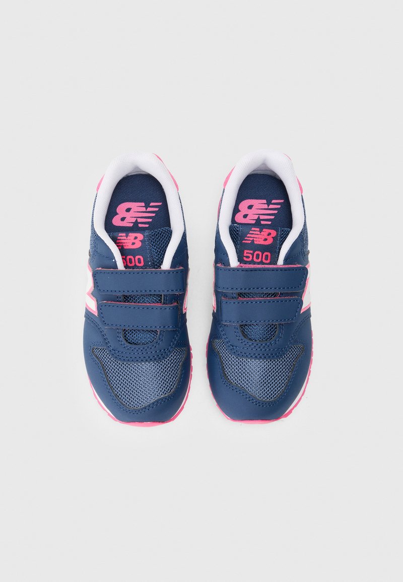 Baskets de sport bleu marine avec des accents roses, dotées d'une texture en mesh, de deux bandes Velcro et d'un logo blanc sur le côté.