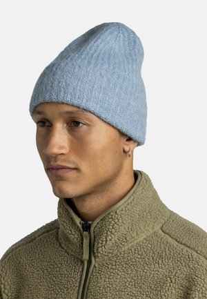 Light blue knitted beanie with a ribbed texture, worn atop a person’s head, paired with a tan, fleece zip-up jacket.
