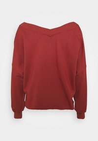 Felpa rossa oversize con scollatura ampia a spalle scoperte, maniche lunghe e polsini a coste. Tessuto morbido con un dettagliato logo discreto.