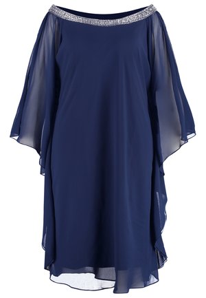 Marineblauwe jurk van chiffon, met een off-the-shoulder ontwerp en een glinsterende versierde halslijn. Vloeiende mouwen en een asymmetrische zoom.
