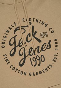 Beige hoodie featuring bold black graphic text. Design includes a circular logo with "Jack Jones," "1990," and "FINE COTTON GARMENTS."