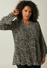 Blouse à imprimé animal avec texture plissée, manches longues et décolleté en V. Les couleurs incluent le noir, le beige et le tan, avec une coupe ample.